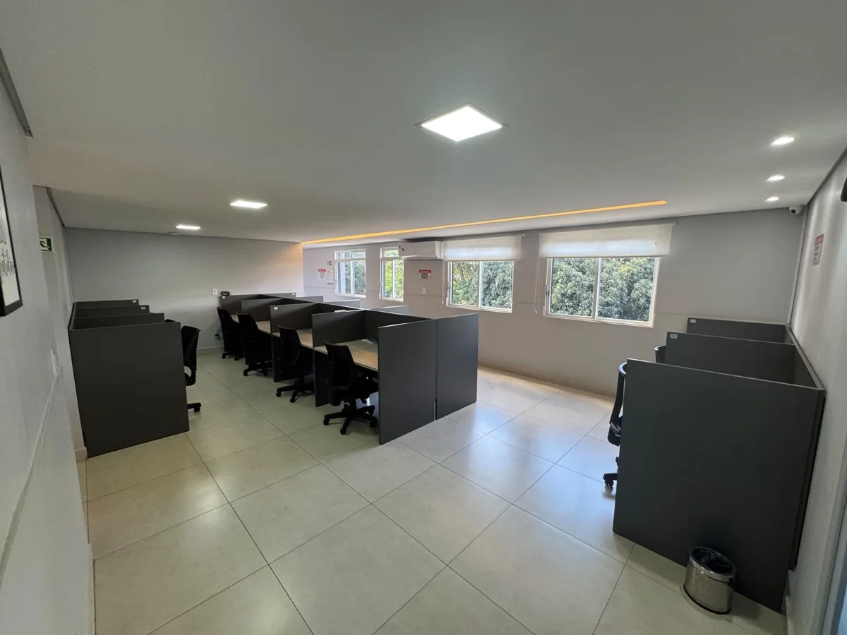 Estações de coworking compartilhadas junto a janelas amplas
