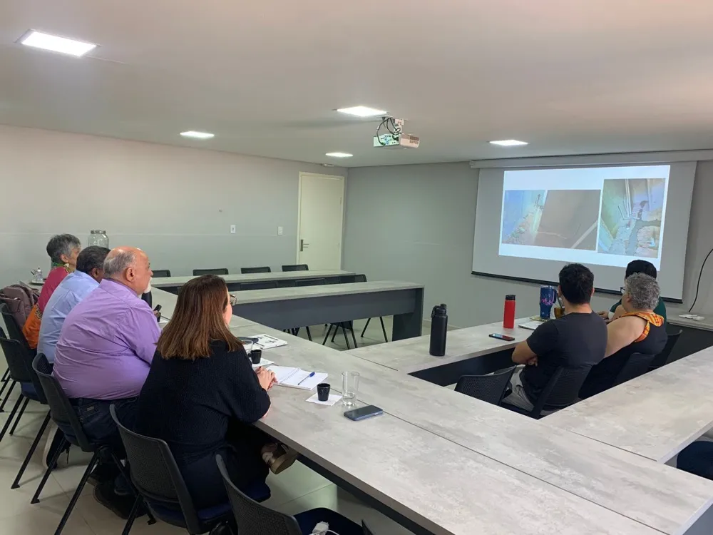 Sala de reunião equipada com TV e mesa para até dez pessoas